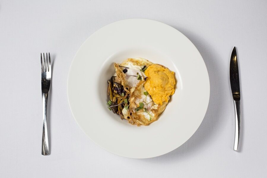 Eurostars Torre Sevilla Esterno foto The image features a white plate with a portion of food arranged in the center. The dish appears to include a mix of ingredients, possibly including a serving of fish or seafood, accompanied by a yellow component that may be a type of sauce or puree.