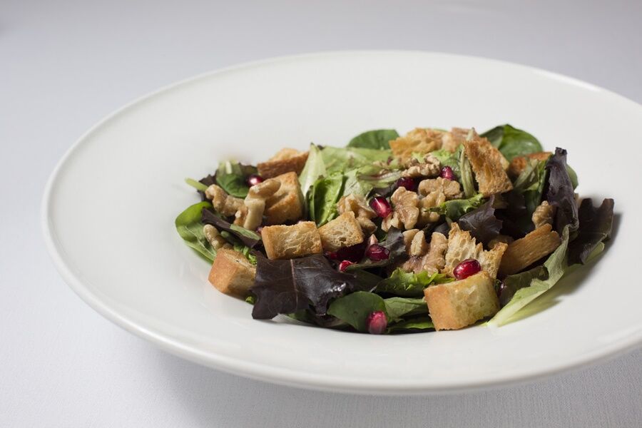 Eurostars Torre Sevilla Esterno foto The photo features a salad presented in a white bowl. The salad includes a mix of leafy greens, possibly lettuce and spinach, along with croutons and small pieces of shredded chicken. It appears to be garnished with pomegranate seeds, adding a pop of